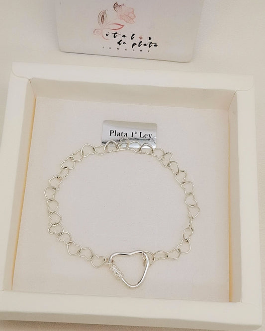 Pulsera de plata con eslabones en forma de corazón y cierre de corazón, presentada en caja blanca de joyería.