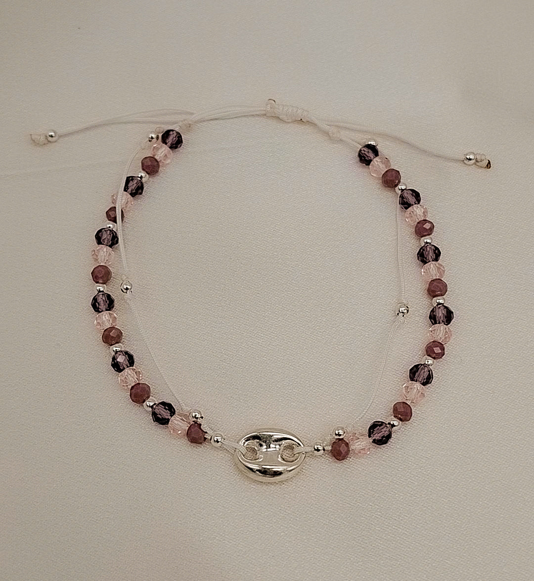 Pulsera ajustable hecha a mano con cristales facetados en tonos amatista y charm central en plata de ley, diseño exclusivo de Pétalos de Plata.