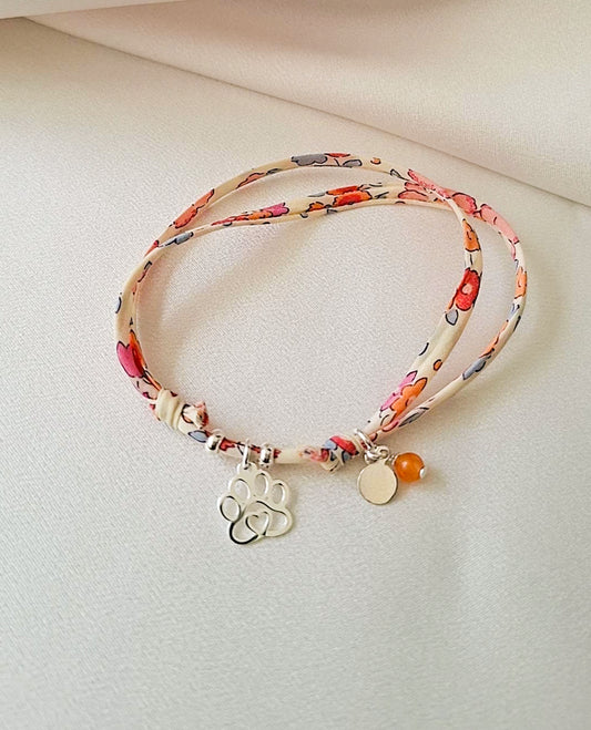 pulsera artesanal, de tela liberty floral con dije de huella de plata.